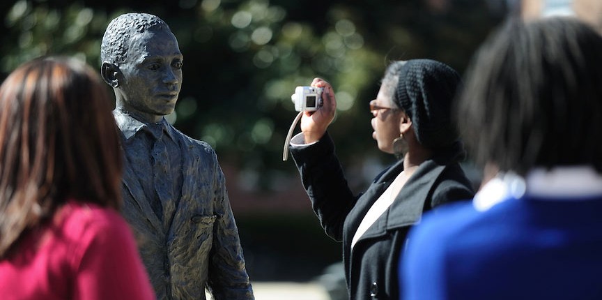 Visitors take photographs at the James Meredith statue.