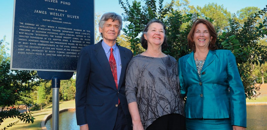 The late Dr. James W. Silver's children pose for a photo near the historical plaque identifying Silver Pond.